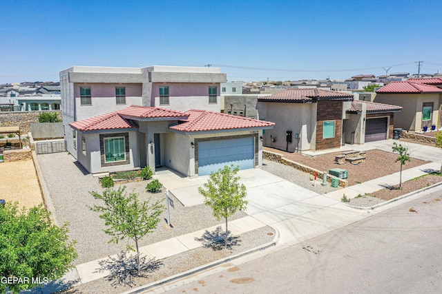mediterranean / spanish home featuring stucco siding, an attached garage, driveway, and a tiled roof