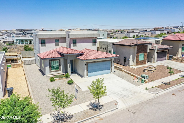mediterranean / spanish house with concrete driveway, a residential view, and stucco siding