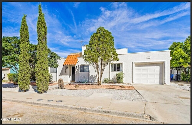 view of front of house featuring a garage, stucco siding, driveway, and a tile roof