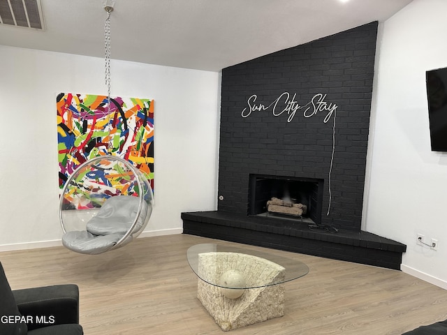 living area featuring visible vents, baseboards, wood finished floors, and vaulted ceiling