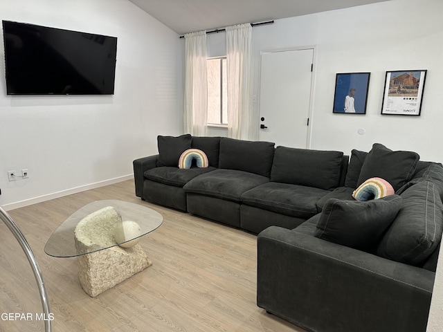 living area with baseboards, wood finished floors, and lofted ceiling