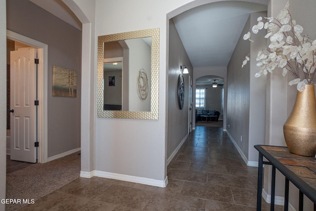corridor with arched walkways and baseboards