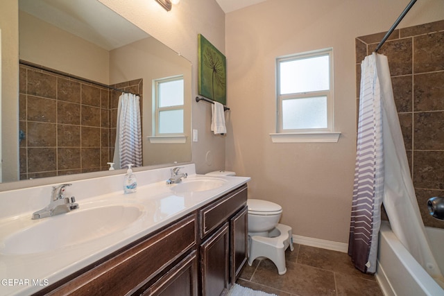 full bathroom with a sink, baseboards, shower / bath combo, and toilet
