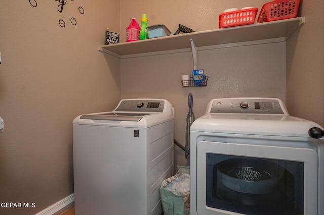 clothes washing area with separate washer and dryer and laundry area
