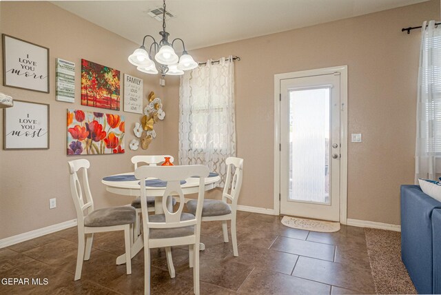 dining space featuring a chandelier, baseboards, visible vents, and a healthy amount of sunlight