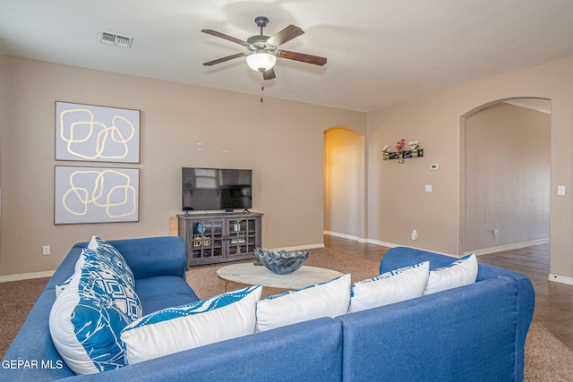 living area with visible vents, arched walkways, baseboards, and ceiling fan