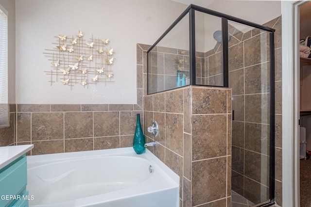 bathroom featuring vanity, a bath, and a stall shower