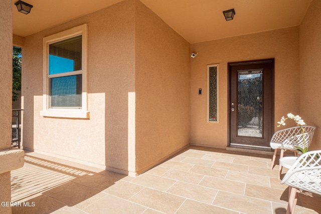 entrance to property featuring stucco siding