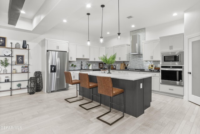 837 Durham Way, Horizon City, TX 79928 - kitchen featuring appliances with stainless steel finishes, wall chimney range hood, a kitchen breakfast bar, tasteful backsplash, and recessed lighting
