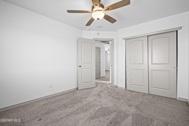 unfurnished bedroom featuring a closet, baseboards, a ceiling fan, and carpet flooring