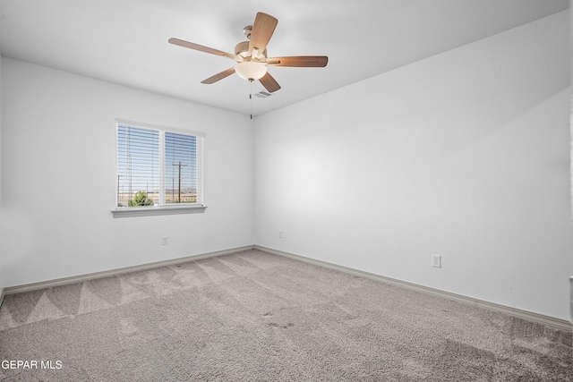 empty room featuring baseboards, a ceiling fan, visible vents, and light carpet