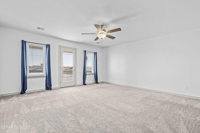 carpeted empty room featuring a ceiling fan, baseboards, and visible vents