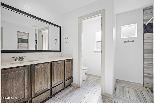 bathroom featuring toilet, visible vents, and vanity