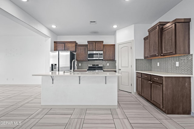 kitchen with visible vents, dark brown cabinets, a sink, light countertops, and stainless steel appliances
