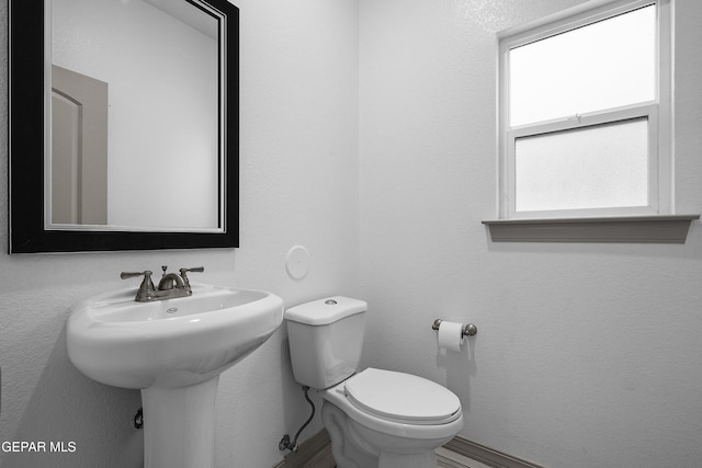half bath featuring toilet and a sink