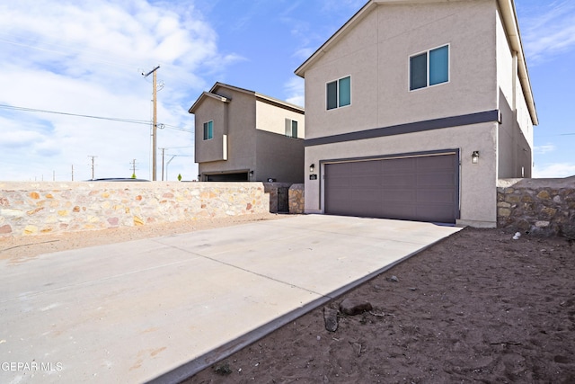 exterior space with stucco siding, driveway, and a garage