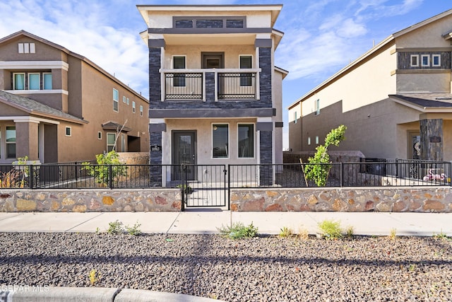 view of front of house featuring a fenced front yard, stucco siding, and a balcony