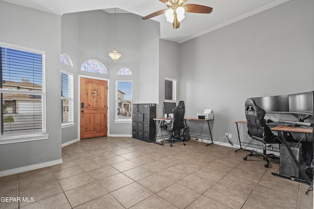 tiled office space with a ceiling fan, baseboards, and a towering ceiling