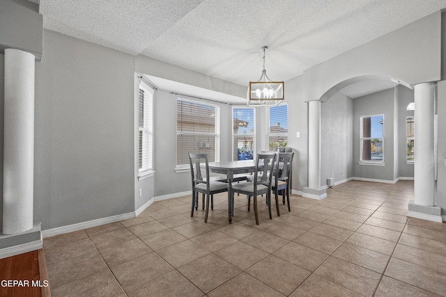 dining space featuring ornate columns, arched walkways, and a wealth of natural light