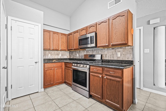 kitchen featuring backsplash, stainless steel appliances, light tile patterned flooring, and visible vents