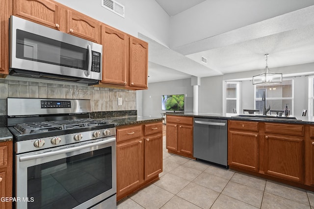 kitchen featuring light tile patterned flooring, a sink, stainless steel appliances, decorative backsplash, and visible vents