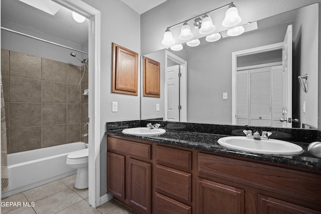 full bath with tile patterned flooring, a sink, double vanity, and toilet