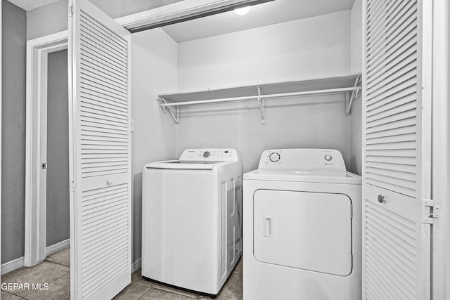 laundry room featuring washing machine and clothes dryer, laundry area, and tile patterned flooring
