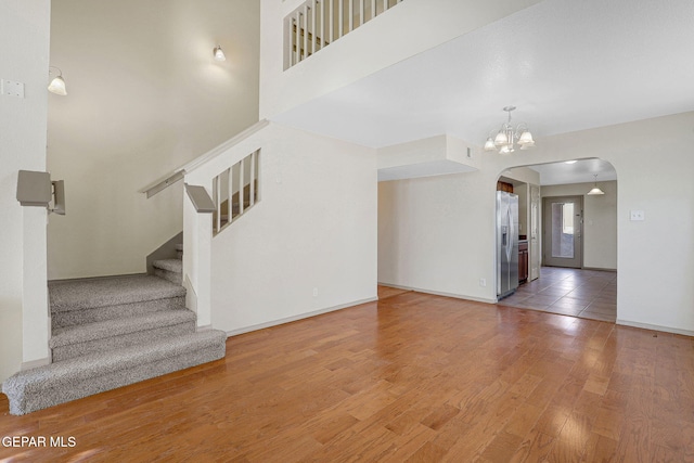 3929 Hueco Valley Dr, El Paso, TX 79938 - interior space with stairs, baseboards, arched walkways, light wood finished floors, and a notable chandelier