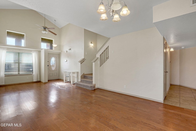 3929 Hueco Valley Dr, El Paso, TX 79938 - interior space with stairs, wood finished floors, baseboards, high vaulted ceiling, and ceiling fan with notable chandelier