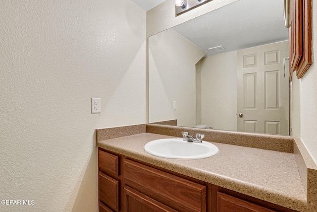 3929 Hueco Valley Dr, El Paso, TX 79938 - bathroom with a textured wall, visible vents, and vanity