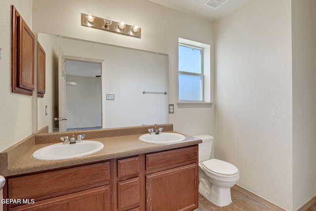 3929 Hueco Valley Dr, El Paso, TX 79938 - bathroom featuring double vanity, a sink, tile patterned flooring, and toilet