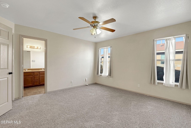 3929 Hueco Valley Dr, El Paso, TX 79938 - unfurnished bedroom featuring baseboards, a sink, light carpet, and ensuite bathroom