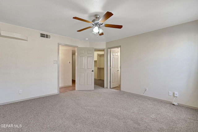 3929 Hueco Valley Dr, El Paso, TX 79938 - unfurnished bedroom with ceiling fan, light carpet, a walk in closet, baseboards, and visible vents
