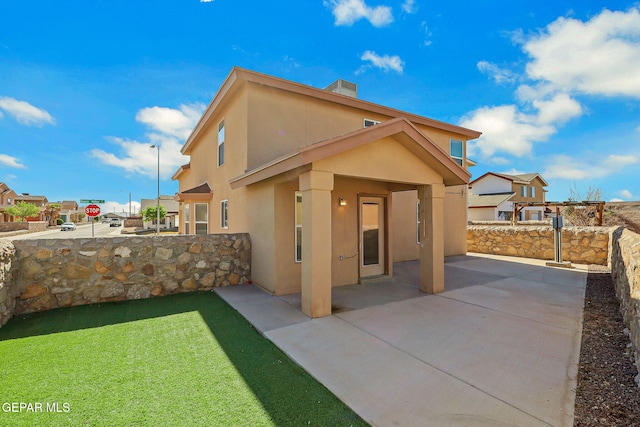 3929 Hueco Valley Dr, El Paso, TX 79938 - back of house featuring a lawn, stucco siding, and a patio area