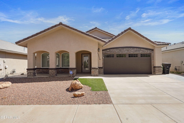 view of front of property featuring a porch, a garage, concrete driveway, stone siding, and stucco siding