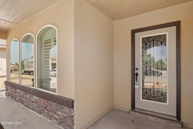 doorway to property featuring stucco siding