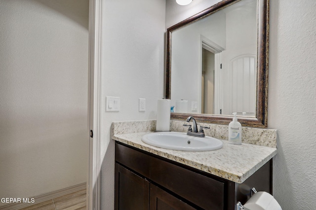 bathroom with vanity and a textured wall