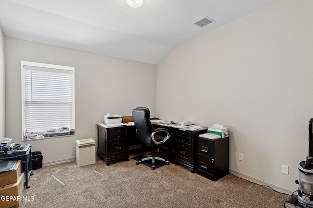 office featuring visible vents, baseboards, lofted ceiling, and light carpet