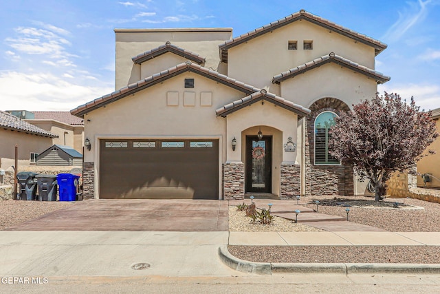 mediterranean / spanish house featuring concrete driveway, stucco siding, a tile roof, and a garage