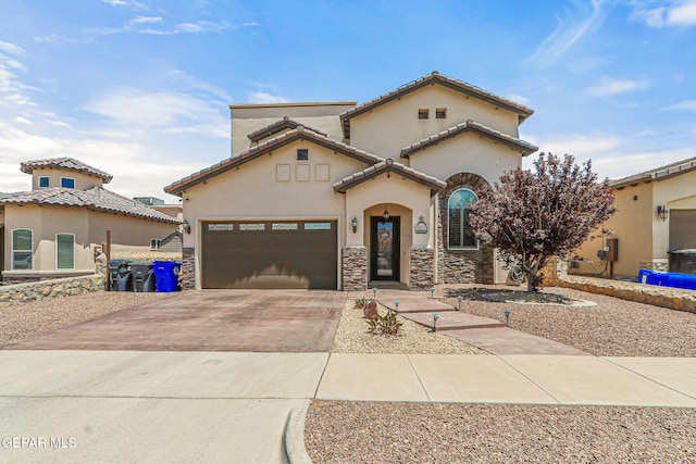 mediterranean / spanish home with a tiled roof, a garage, stucco siding, concrete driveway, and stone siding