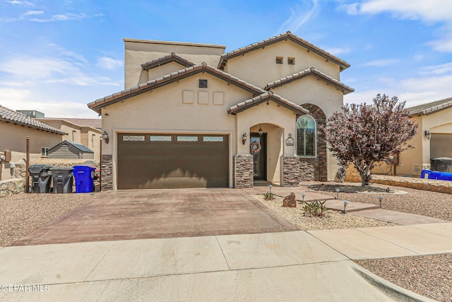 mediterranean / spanish house featuring stone siding, a garage, stucco siding, a tile roof, and concrete driveway