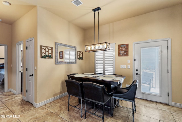dining space featuring light tile patterned floors, visible vents, and baseboards