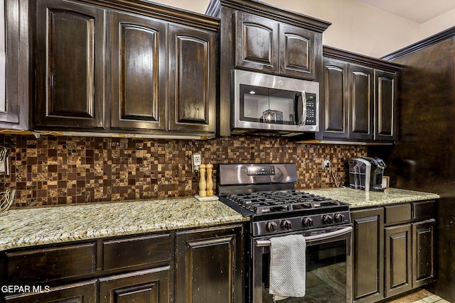 kitchen featuring light stone counters, dark brown cabinets, and appliances with stainless steel finishes