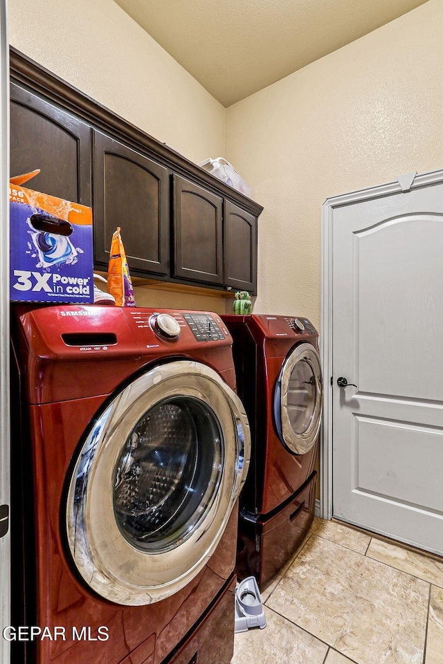 laundry room featuring washing machine and clothes dryer and cabinet space