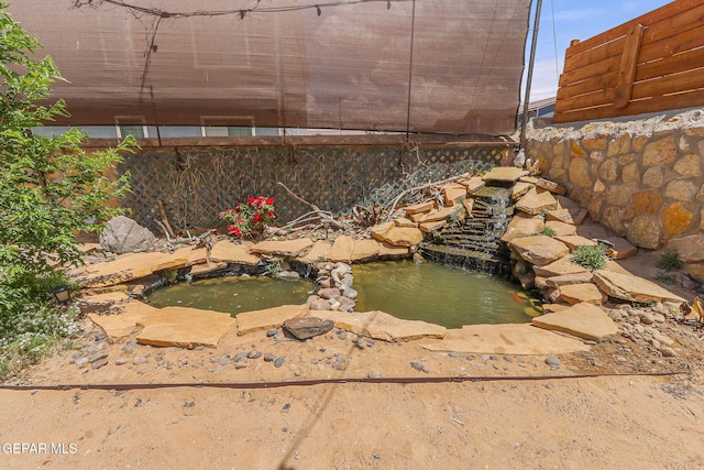 exterior details with a small pond and fence