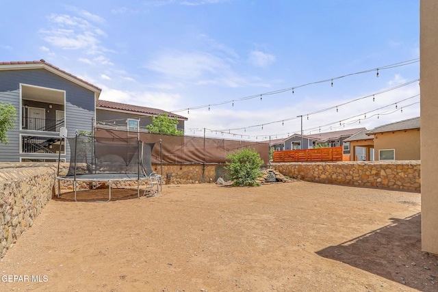 view of yard with a fenced backyard and a trampoline