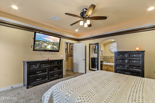 carpeted bedroom featuring baseboards, ceiling fan, visible vents, and arched walkways