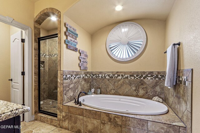 full bath featuring a stall shower, tile patterned flooring, a bath, and vanity