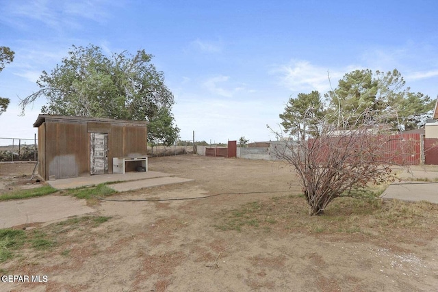 12365 Stubbs Dr, San Elizario, TX 79849 - view of yard featuring fence, an outdoor structure, and a storage unit