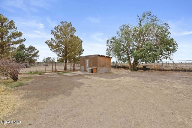 12365 Stubbs Dr, San Elizario, TX 79849 - view of yard featuring fence, an outdoor structure, and a storage unit